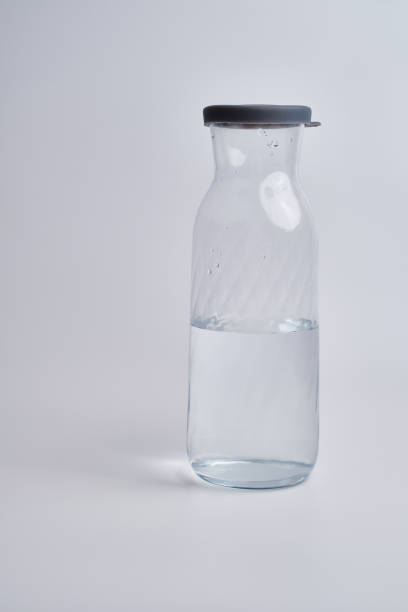 istock Glass bottles with water on a light background. Place for text 1620940123