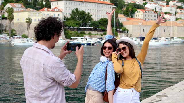 Young Man Taking Pictures Of His Two Female Friends In Dubrovnik Bay