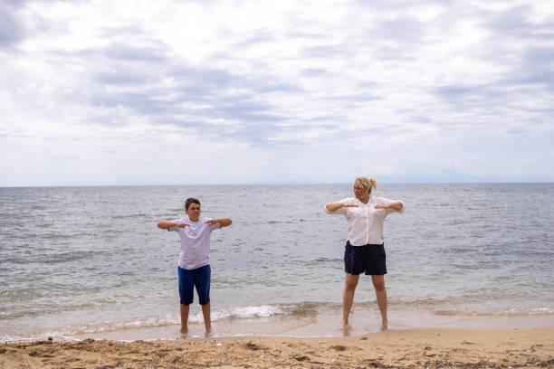istock Active and healthy mother and son exercising on the beach, during their vacation 1620956561