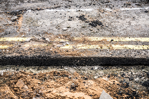 Asphalt at the edge of a street covered with construction materials during major construction.