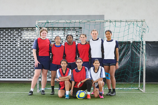 Multiracial Group Female Soccer Team Photo looking at camera confidently