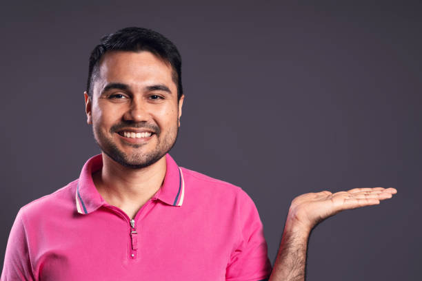 ritratto di brasiliano che indossa la polo, dal davanti, con il palmo della mano sinistra esteso, all'altezza delle spalle, sorridente e guardando la macchina fotografica - belém - pará - brasile - polo shirt flash foto e immagini stock