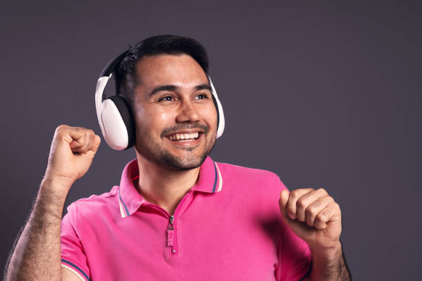 ritratto di un brasiliano che indossa una polo, dal davanti, che si gode la musica con le cuffie, sorride e guarda di lato - belém - pará - brasile - polo shirt flash foto e immagini stock