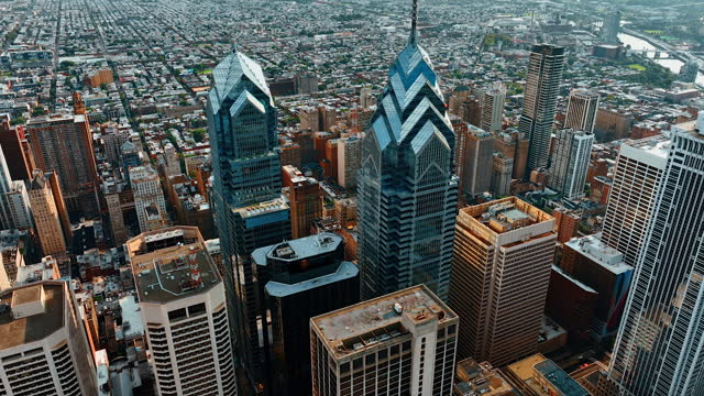 Approaching marvelous skyscraper complex of beautiful Philadelphia. Plain cityscape and river at backdrop. Top view.