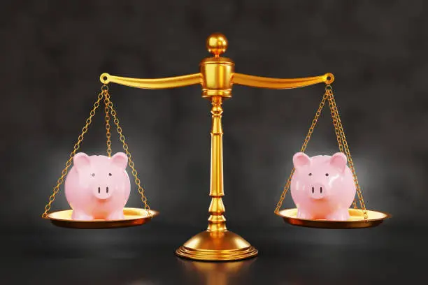 Photo of Pink piggy banks on each side of a golden justice scale on dark background. Illustration of choices of stock investment