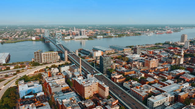 The Ben Franklin Bridge view over the Delaware River in Philadelphia, USA. Beautiful cityscape on sunny day from aerial perspective.