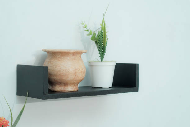 wooden shelves with beautiful plants, alarm clock, toy cars and books on a light wall - ice shelf imagens e fotografias de stock