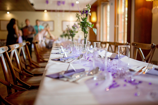 Elegant table setup in purple pastels for a restaurant wedding, indoors