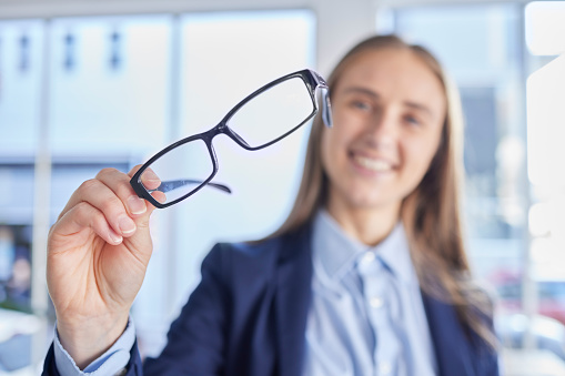 Optometry, eyesight and portrait of woman with spectacles with prescription lens after eye test. Healthcare, vision and female patient or customer holding glasses frame for eye care in optical store