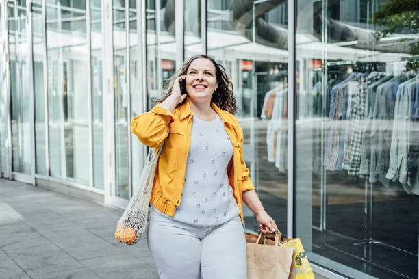 istock How to Build a Plus Size Capsule Wardrobe for a big belly. Styling Basic Capsule Wardrobe Outfits. Outdoor portrait of stylish curvy woman on shopping 1621056221