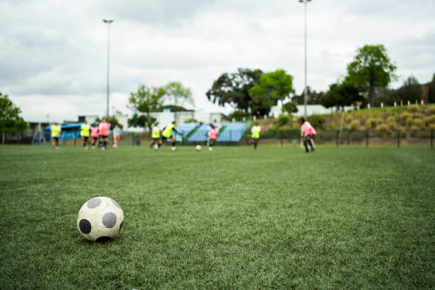 istock Soccer ball sitting on a sports field during a team practicing 1621068708
