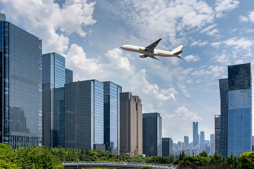 plane fly over modern cityscape with office buildings and skyline. economical development concept.