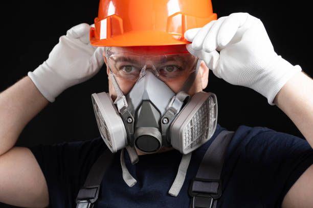 istock A man wearing a helmet, respirator and goggles on a black background 1621080459
