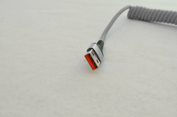 istock USB cable connection detail highlighted on a clear surface, perfect for modern technology concepts. Cable that provides speed and data transfer. 1621092358