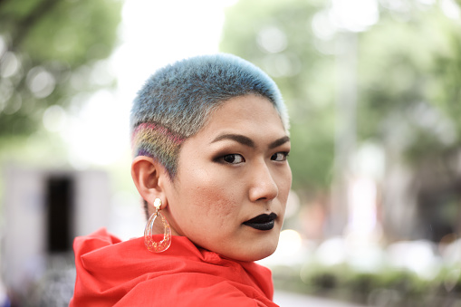 Generation Z and LGBTQ Transgender Female : Asian female transgendered person in outdoors.
Harajuku Tokyo Japan.
Gen-Z Her hair is shaved and add color the rainbow.