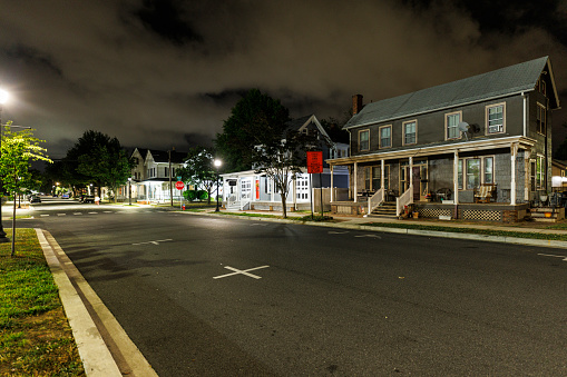 Houses in lights lining night streets of Dover, Delaware Residential area with road leading to horizon at night