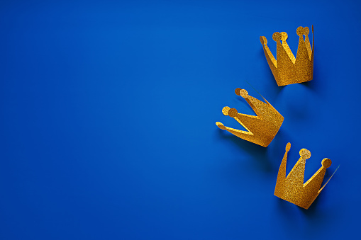 Happy Epiphany Day, Three Kings Day greeting card with three gold crowns on blue background. Concept for Dia de Reyes Magos day, three Wise Men, Epiphany Christian feast day.
