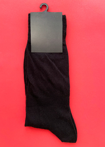 New black socks with empty label on the red background
