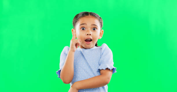 istock Face, green screen and child in studio with idea, answer or solution, happy and excited on mockup background. Portrait, wow and girl with surprised, emoji and lightbulb moment or eureka isolated 1621199412