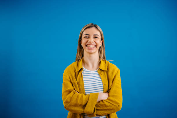 istock Happy Young Woman Standing Against A Blue Background 1621202080