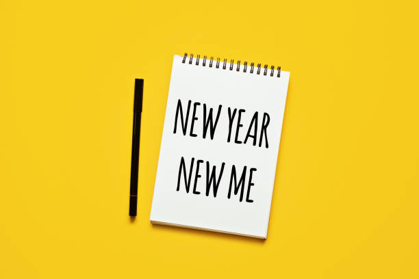 istock New year new me text in open notepad on yellow background. Setting goals and new years resolution. New year loading. 1621204220