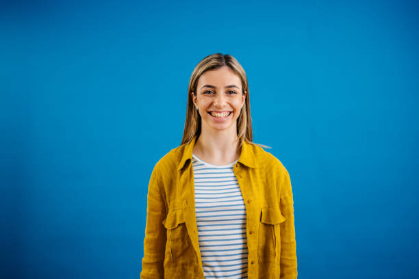 istock Happy Young Woman Standing Against A Blue Background 1621204236