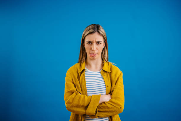istock Young Woman Making A Funny Face While Standing Against A Blue Background 1621206414