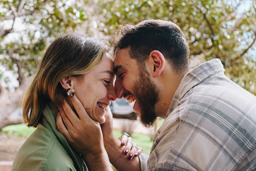 Young guy kissing girlfriend, smiling