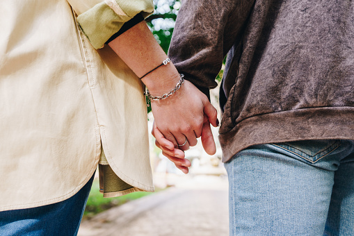 Close-up of a couple holding hands outdoors