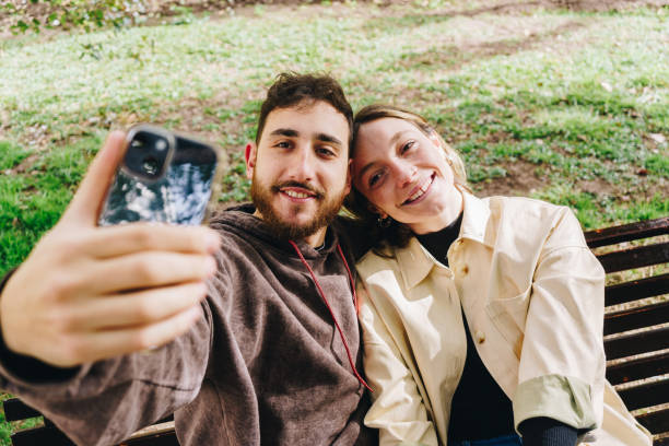 istock Couple taking a selfie embracing at the public park 1621234970