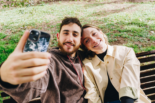 Couple taking a selfie embracing at the public park
