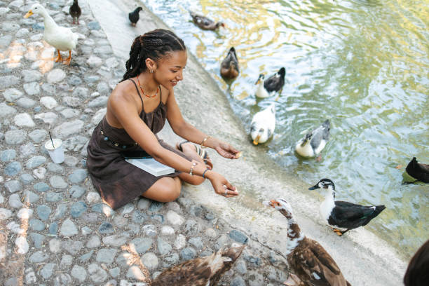 istock African woman feeding the ducks 1621238799