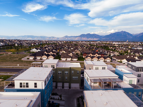 Observing from the air, Salt Lake City's suburbs sprawl—developing neighborhoods, lively roads, and bustling shopping zones. Mountains frame the horizon, while subdivisions unveil meticulously designed parks and greens.