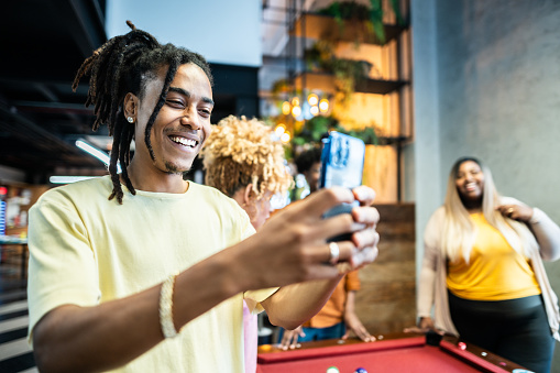 Young businessman using phone/taking photos in the lobby of office