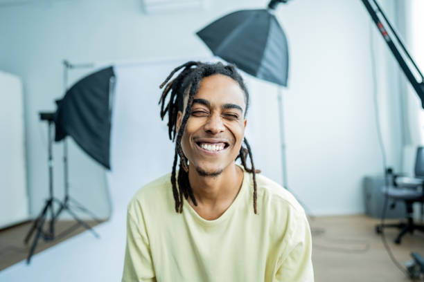 Portrait of a young model man winking eye at studio