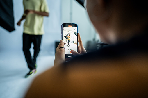 Photographer taking photos/filming a model dancing at studio