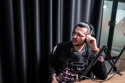 Mid adult man talking during a interview at podcast