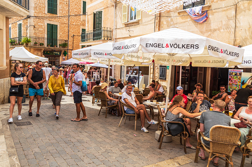 Santanyí, Spain, July 21, 2018; Cozy small street with terraces in the picturesque town of Santanyí on the Mediterranean island of Mallorca in Spain.