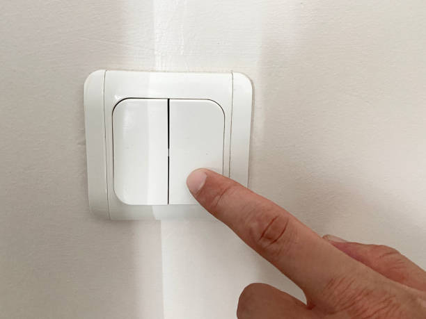 istock Turning on or off electric lamp switch. Finger pushing electric light switch push button on the wall 1621304881