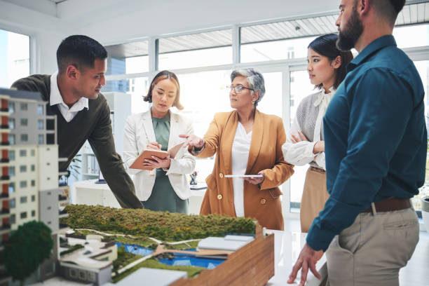 istock Creative people, real estate and meeting with 3D model, building project or team startup at office. Group in teamwork discussion for architecture, brainstorming or planning strategy at the workplace 1621360490
