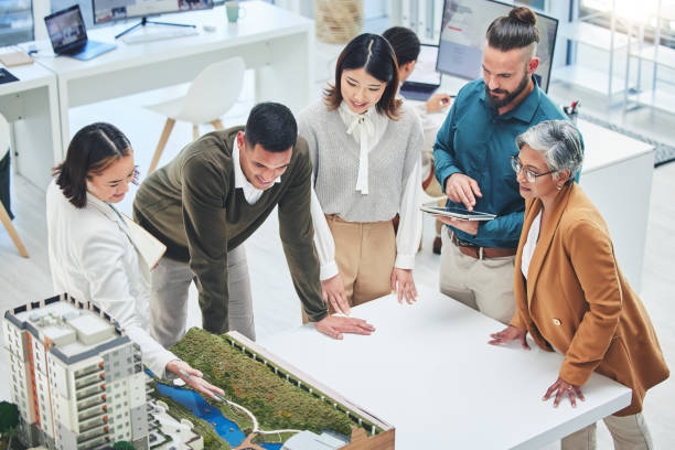istock Creative people, real estate and meeting with 3d model for building design, architecture or property at office. Architect team or group in project discussion, planning or brainstorming at workplace 1621360508