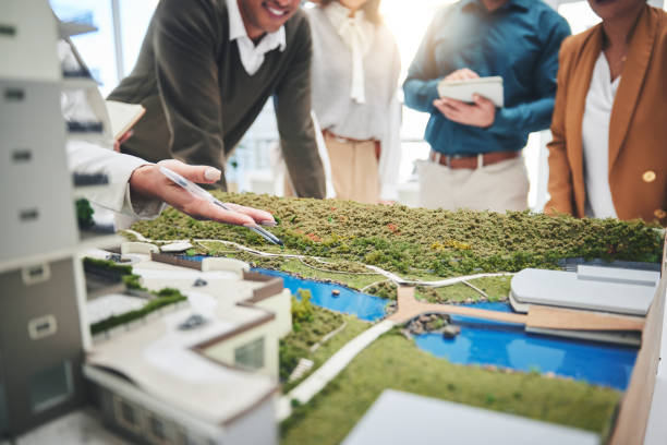 istock Creative people, hands and real estate with 3d model of building design, architecture or property at office. Closeup of group architect team in meeting, project planning or floor layout at workplace 1621360529
