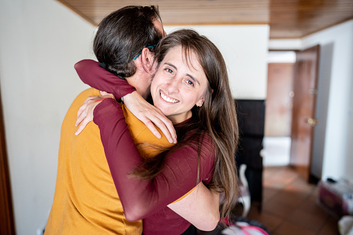 Portrait of young woman embracing her husband at home