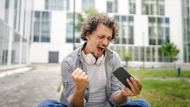 istock man use mobile smart phone play video games sit outdoor 1621375810
