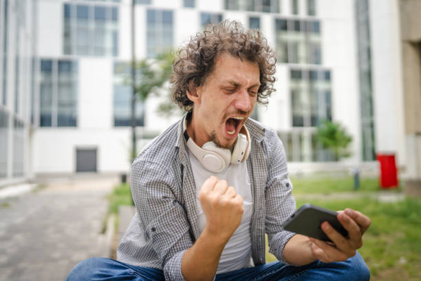 istock man use mobile smart phone play video games sit outdoor 1621375811