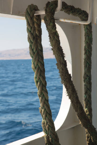 Close-up of rope on ship, blue sea in background.