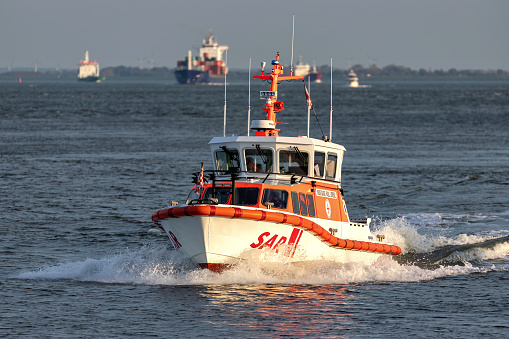 New York,United States - May 29, 2011:  US coast guard boat is navigating near the upper bay at New York. Brooklyn buildings on the Background.