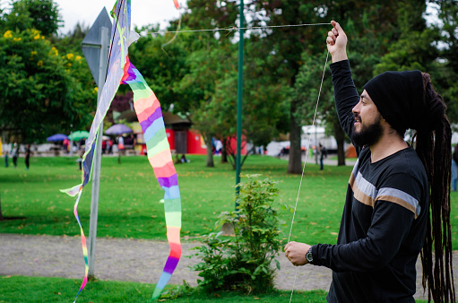 man flying kite in urban park