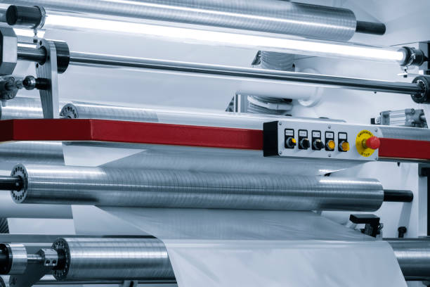 istock Automatic polyethylene plastic bag production machine with lighting effect. Close-up of the roller of the plastic bag production machine in the light blue scene. product packaging concept 1621406308