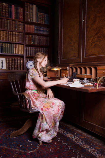 istock Young lady at her writing desk in the old study. 1621409098